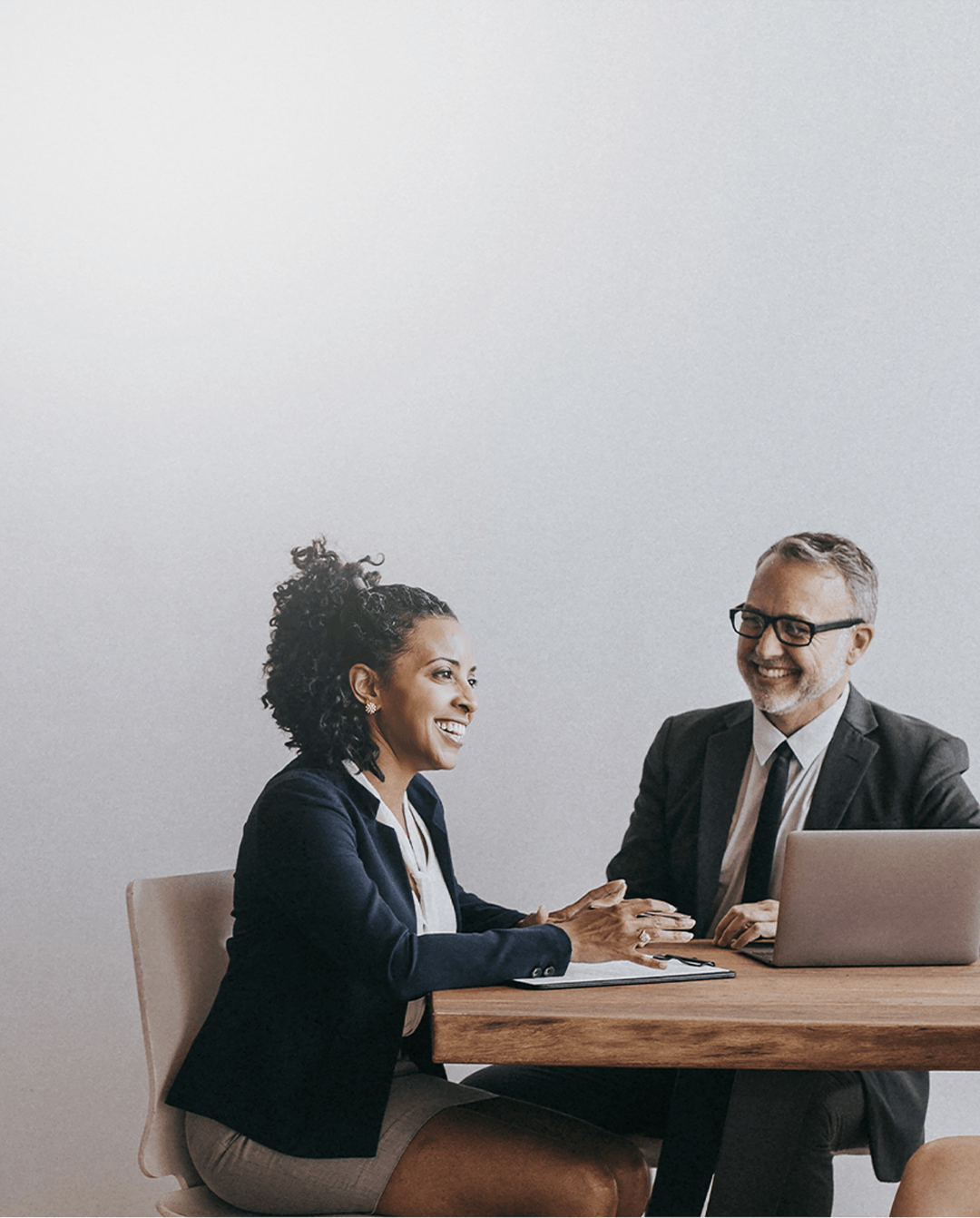 Uma mulher e um homem em um reunião de negócios sorrindo