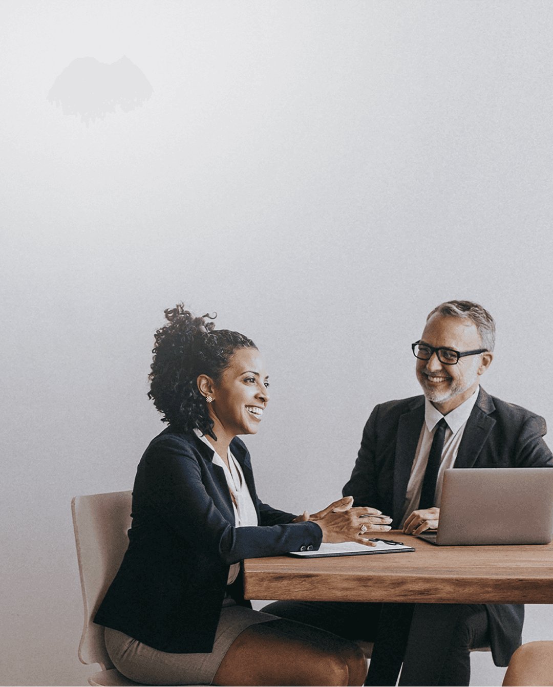 Uma mulher e um homem em um reunião de negócios sorrindo